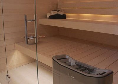 Family sauna with glass door, heater and bench