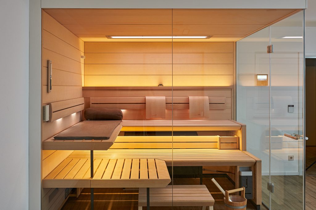 A sleek sauna room with wooden seating, offering a tranquil atmosphere for health and relaxation in a heated environment.